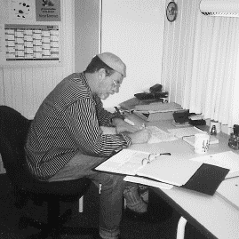 [Billede: Mand, som sidder ved et skrivebord og skriver.]