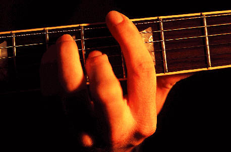 [Billede: Person, der tager en akkord på en guitar.]