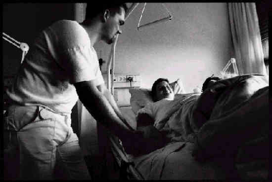 {Billede: En sengeliggende patient bliver tilset]