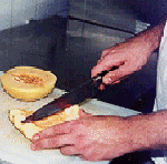 [Billede: Person, som skærer en melon i stykker.]