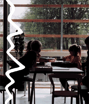 [Billede: Elever sidder ved et bord og leger/maler]