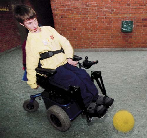 [Billede: Her ses en en dreng, der sidder i en kørestol, og som spiller bold.]