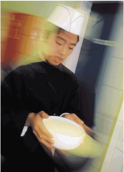 [Billede: En kokkeelev, der står med en hvid skål i hænderne og er iklædt en hvid kokkehue]