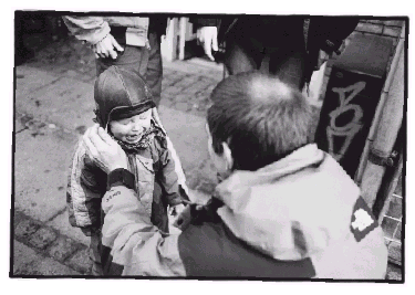 [Billede: Dreng, der grænder, bliver trøstet af en pædagog]