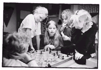 [Billede: Børn samlet om et skakspil]