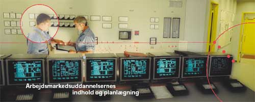 [Billede: Her ses to mænd, der står og taler sammen i et arbejdslokale. Der kan bl.a. ses en række computere.]